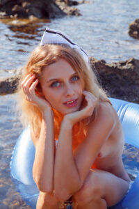 Woman relaxing on inflatable at seaside.